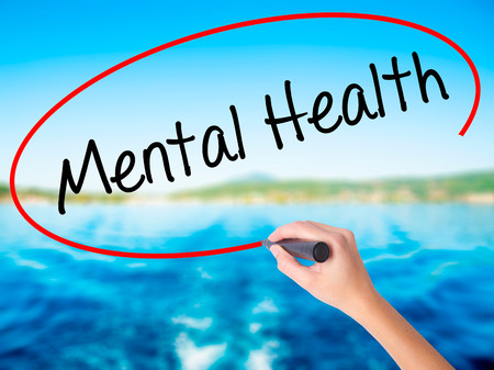 Woman Hand Writing Mental Health on blank transparent board with a marker isolated over water background. Business concept. Stock Photoの写真素材