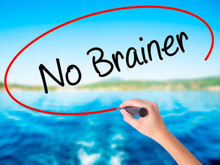 Woman Hand Writing No Brainer on blank transparent board with a marker isolated over water background. Business concept. Stock Photoの写真素材