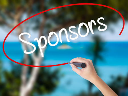 Woman Hand Writing Sponsors with black marker on visual screen. Isolated on nature. Business concept. Stock Photoの写真素材