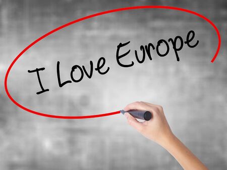 Woman Hand Writing I Love Europe with black marker over transparent board. Isolated on grey. Business concept. Stock Photoの写真素材