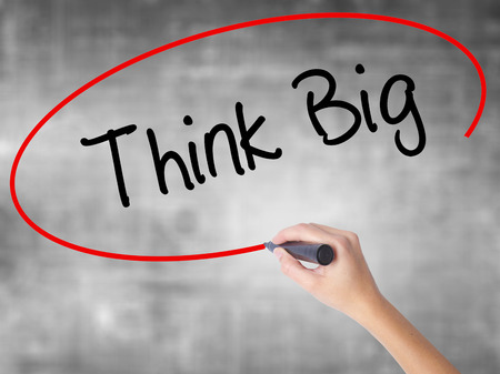 Woman Hand Writing Think Big with black marker over transparent board. Isolated on grey. Business concept. Stock Photoの写真素材