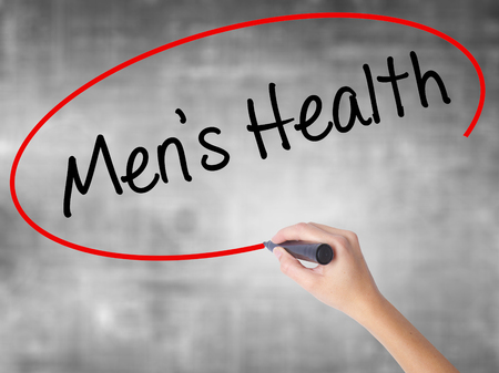 Woman Hand Writing Men's Health with black marker over transparent board. Isolated on grey. Business concept. Stock Photoの写真素材