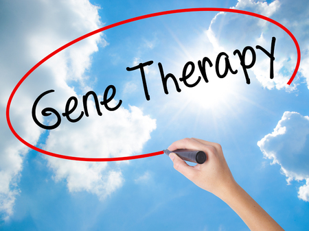 Woman Hand Writing  Gene Therapy  with black marker on visual screen. Isolated on Sunny Sky. Business concept. Stock Photoの写真素材