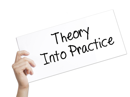 Theory Into Practice Sign on white paper. Man Hand Holding Paper with text. Isolated on white background.   Business concept. Stock Photoの写真素材