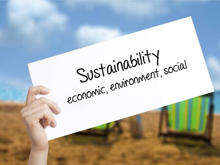 Sustainability  economic, environment, social Sign on white paper. Man Hand Holding Paper with text. Isolated on holiday background.  technology, internet concept.の写真素材