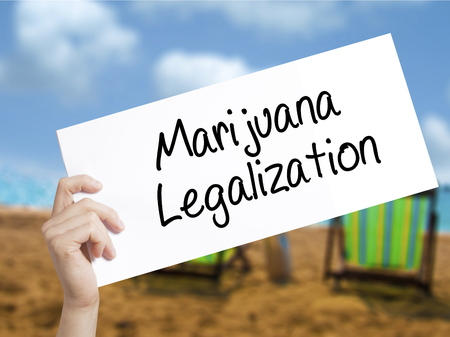 Marijuana Legalization Sign on white paper. Man Hand Holding Paper with text. Isolated on holiday background. Live,  Business concept. Stock Photoの写真素材