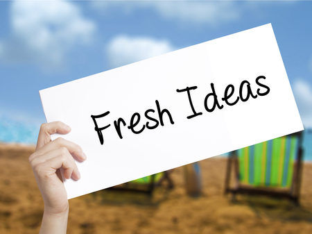 Fresh Ideas Sign on white paper. Man Hand Holding Paper with text. Isolated on holiday background.   Business concept. Stock Photoの写真素材