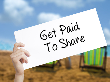 Get Paid To Share Sign on white paper. Man Hand Holding Paper with text. Isolated on holiday background.  Business concept. Stock Photoの写真素材