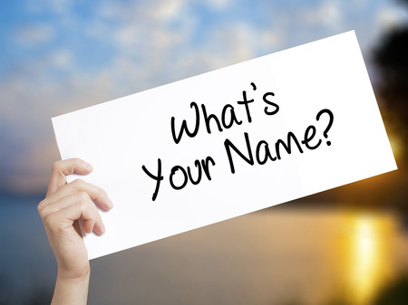 What's your Name? Sign on white paper. Man Hand Holding Paper with text. Isolated on sunset background.  Business concept. Stock Photoの写真素材