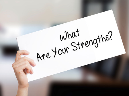 What Are Your Strengths? Sign on white paper. Man Hand Holding Paper with text. Isolated on Office background.   Business concept. Stock Photoの写真素材