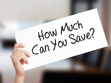 How Much Can You Save? Sign on white paper. Man Hand Holding Paper with text. Isolated on Office background.   Business concept. Stock Photoの写真素材