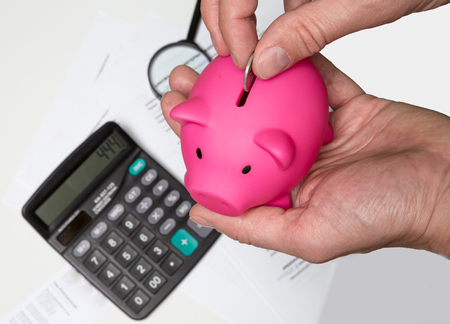 Man hand putting money to piggy bank - Stock imageの写真素材