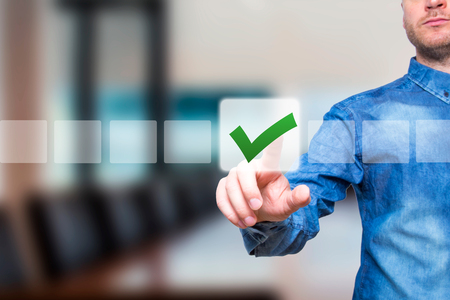 Young male hand touching, pressing modern button and ticking check box out of empty boxes on digital screen interface. Isolated on office Business technology concept. Stock Imageの写真素材