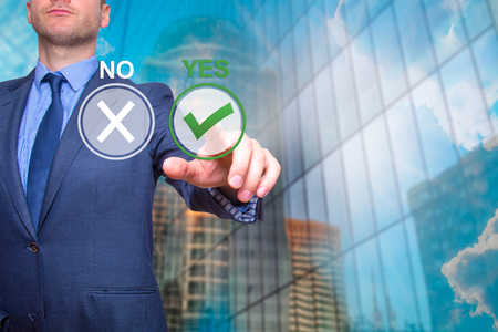 Hand of businessman press Yes button. Concept of decision making. Isolated on Skyscraper. Stock Imageの写真素材