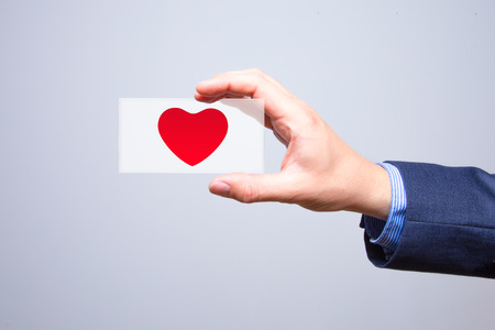 Businessman holding a red heart in his hand - crm - service mindの写真素材