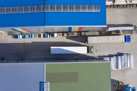 Aerial view, logistic warehouse, trucks ride near warehouse ramp.の写真素材