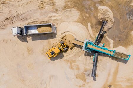 Aerial view of sand quarry with trucks and bulldozers. Heavy bulldozer loading  sand,の写真素材