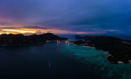 Aerial view of Phi Phi, Maya beach with blue turquoise seawater, mountain hills, and tropical green forest trees at sunset with Andaman sea in Phuket island in summer, Thailand in travel trip. Nature. Panoramaの写真素材