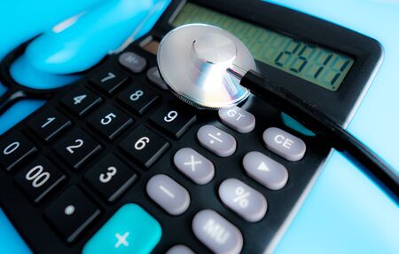 Calculator and stethoscope on financial statement concept for finance health check or cost of healthcareの写真素材