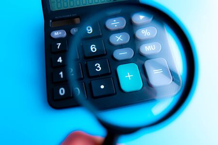 Concept of medical expenses or medical insurance for blog title and header. Stethoscope,white calculator and magnifying glass on wooden background.の写真素材