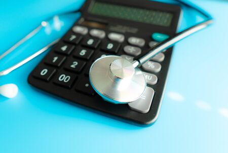 Calculator and stethoscope on financial statement concept for finance health check or cost of healthcareの写真素材