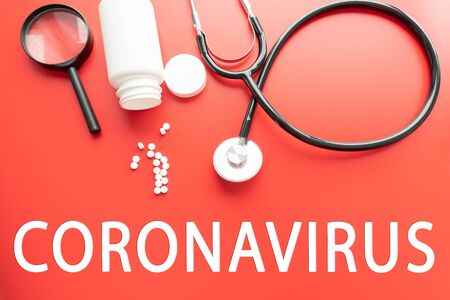Text phrase Coronavirus syringe eyeglasses and stethoscope on red pastel background. Novel coronavirus 2019-nCoV MERS-Cov covid-19 middle East respiratory syndrome coronavirus virus vaccine conceptの写真素材