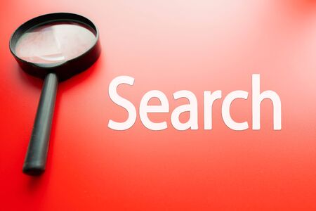 Word search written on red background and  magnifying glass next to itの写真素材