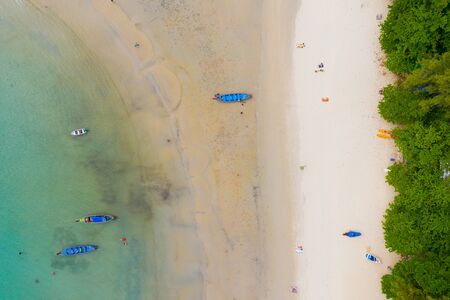 Aerial view or top view of long-tailed boat is floating on the emerald sea. Calm andaman sea at Phuket, Thailand. Kata beachの写真素材