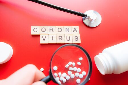 Coronavirus COVID-19 concept image wit text seen through a magnifying glass. Red Backgroundの写真素材
