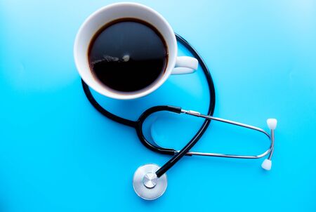 coffee cup and stethoscope, relaxing concept for doctor. On a blue background. Medical background conceptの写真素材