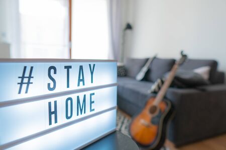 Coronavirus home sign lightbox with text hashtag #STAYHOME glowing in light. COVID-19 banner to...