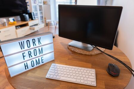 Working from home remote work inspirational social media lightbox message board next to monitor and keyboard and mouse, COVID-19 quarantine closure of all. Apartment backgroundの写真素材