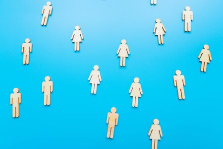 Wooden figures on blue background as a symbol of team building. Organization group people in business. Cooperation and partnership.の写真素材