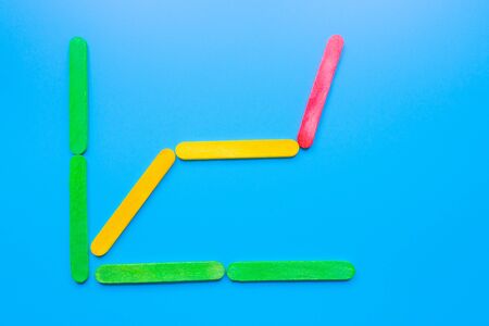Growth bar chart, Graph diagram made with wooden sticks isolated on blue background and space for...