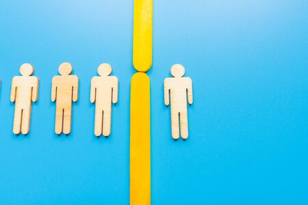 Selected wooden figure on blue background. The concept of finding an employee in business. HR...