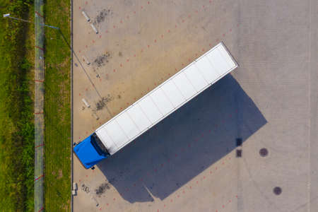Aerial top view of truck and cargo trailer unloading in logostics center.の写真素材