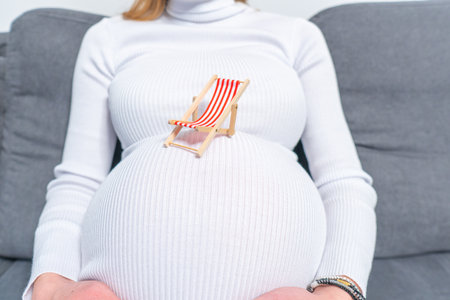 Pregnant woman touching her belly on the beach. Vacation concept