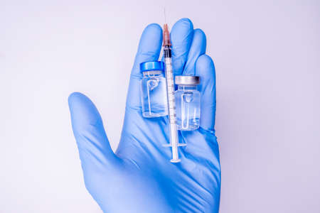 Syringe in a hand of a doctor or nurse and medicine or vaccine vial. Vaccination and immunization concept. Medicine and health care. Vaccine trials and research. Pharmacy. COpy spaceの写真素材