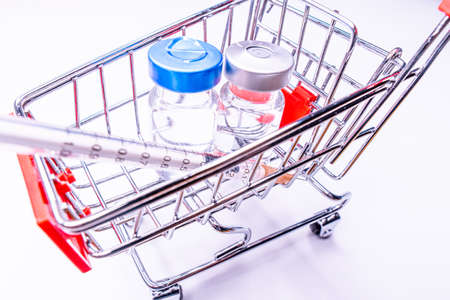 vaccine cost. How much is vaccine Injection on blue background with shopping car and money.の写真素材