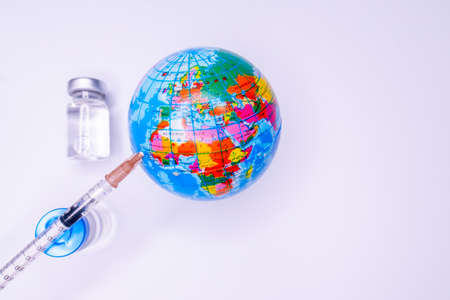 Medical hand injecting a vaccine into planet Earth.の写真素材