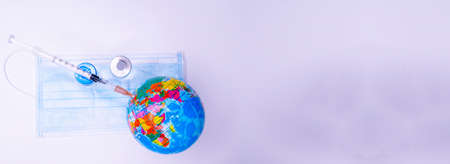 Medical hand injecting a vaccine into planet Earth. Concept of a cure for all people against the...