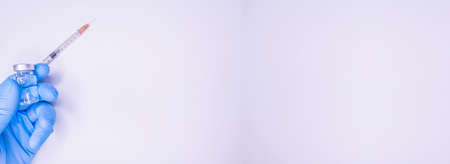 Covid 19 vaccine, immunity and medical treatment concept. Coronavirus syringe and needle. Doctor or nurse working in health care wearing a mask. Corona virus injection shot research. NCOV pandemic. Copy Spaceの写真素材