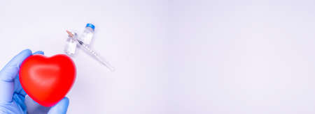 a hand in a medical glove holds an ampoule containing the covid-19 vaccine, invented to prevent the...