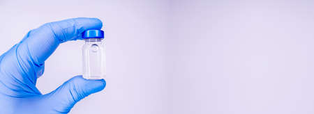 Medicine bottle for injection in hand, palm of a doctor. Medical glass vial for vaccination. Science...