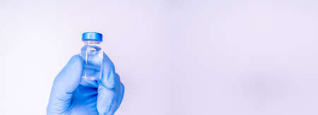 Medicine bottle for injection in hand, palm of a doctor. Medical glass vial for vaccination. Science...