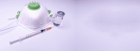 Medical bottle, vials, syringes and face mask on blue background with copy space. Vaccination session and immunity improvement. Copy Spaceの写真素材