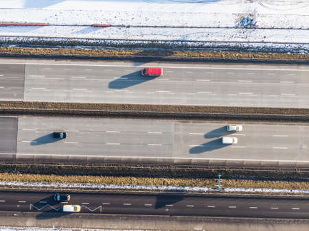 Aerial Follow Shot of White Semi Truck with Cargo Trailer Attached Moving Through Industrial Warehouse, Rural Area.の写真素材