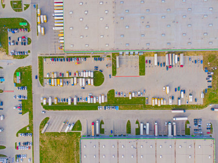 Aerial view of modern storage warehouse with solar panels on the roof. Logistics center in industrial city zone from drone view. Background texture concept.の写真素材