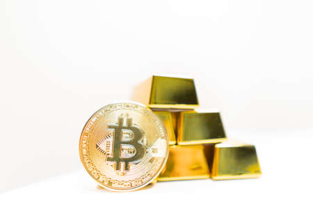 Bitcoin laying on stacked gold bars (gold ingots) rendered with shallow depth of field. Bitcoin as...