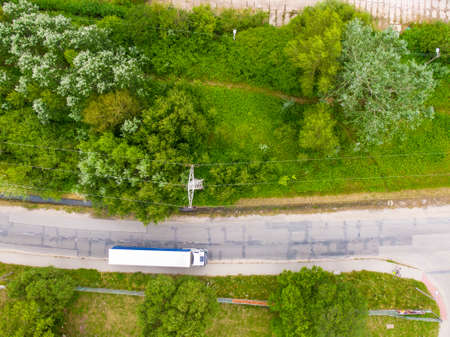Aerial view of goods warehouse. Logistics center delivery in industrial city zone from above. Aerial view of trucks loading at logistic centerの写真素材
